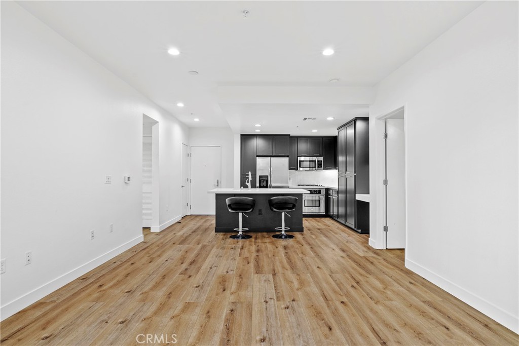 21301 Erwin Street, Unit 206 Woodland Hills, CA 91367 - Photo 6 of 34 a kitchen with a sink stainless steel appliances and cabinets