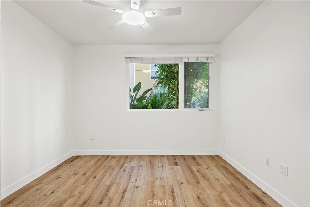 21301 Erwin Street, Unit 206 Woodland Hills, CA 91367 - Photo 9 of 34 an empty room with wooden floor and windows