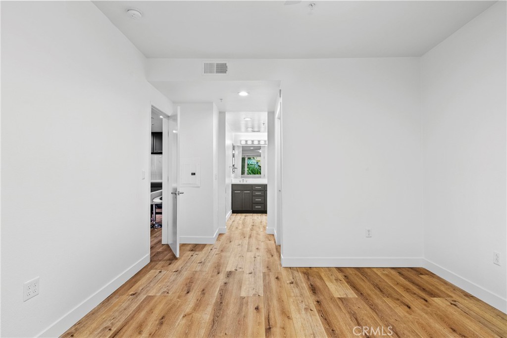 21301 Erwin Street, Unit 206 Woodland Hills, CA 91367 - Photo 10 of 34 a view of a hallway with wooden floor and a bathroom