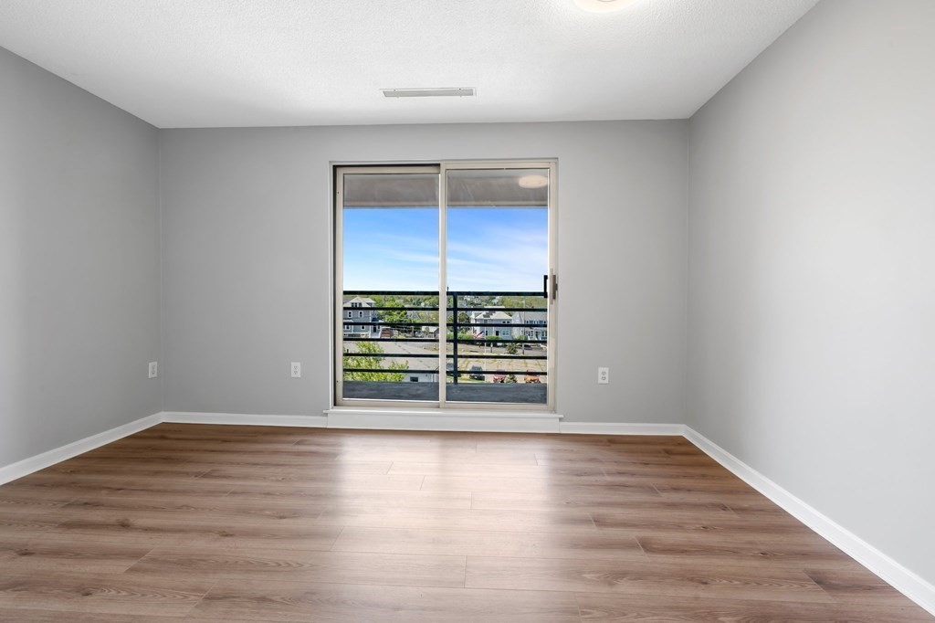 20 Rockland House Road, Unit 402 Hull, MA 02045 - Photo 14 of 40 a view of an empty room with wooden floor and a window