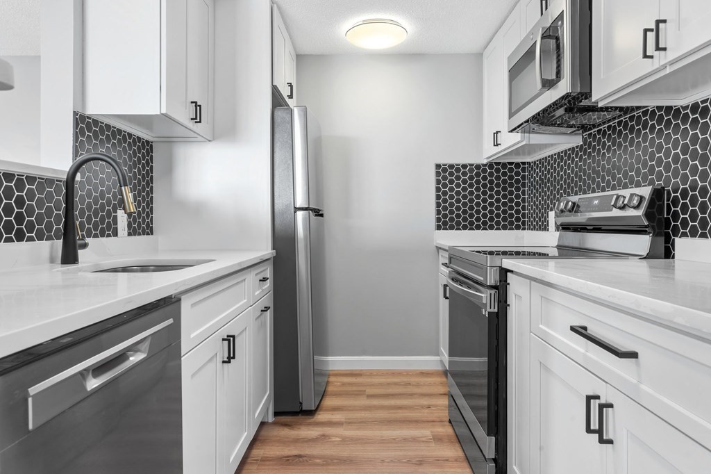 20 Rockland House Road, Unit 402 Hull, MA 02045 - Photo 3 of 40 a kitchen with granite countertop a sink stove and cabinets