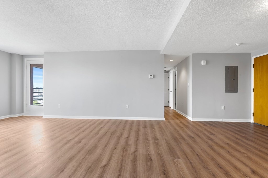 20 Rockland House Road, Unit 402 Hull, MA 02045 - Photo 5 of 40 a view of an empty room with wooden floor and a window