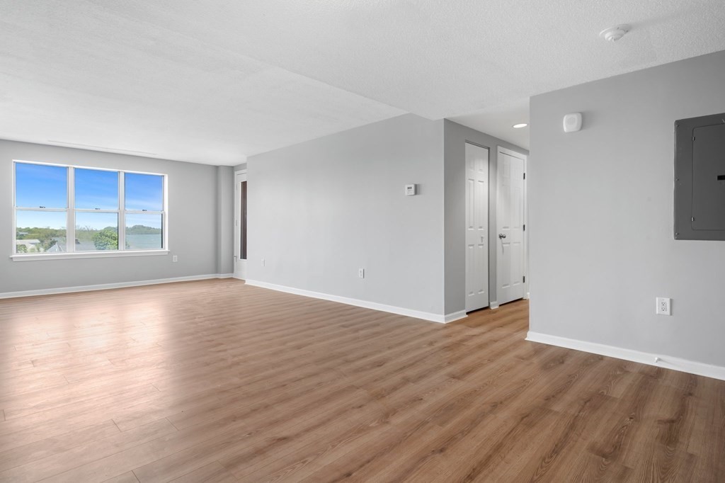 20 Rockland House Road, Unit 402 Hull, MA 02045 - Photo 6 of 40 a view of an empty room with wooden floor and window