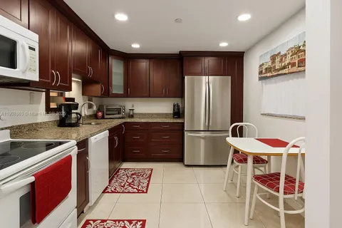 a kitchen with stainless steel appliances granite countertop a refrigerator stove microwave and sink