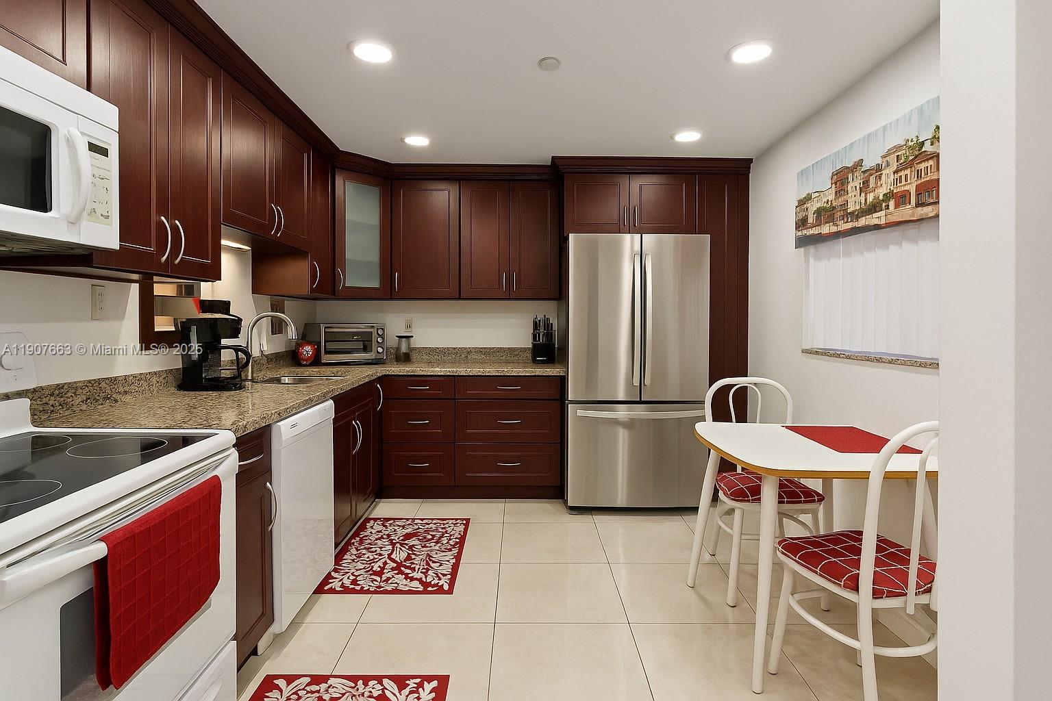 a kitchen with stainless steel appliances granite countertop a refrigerator stove microwave and sink