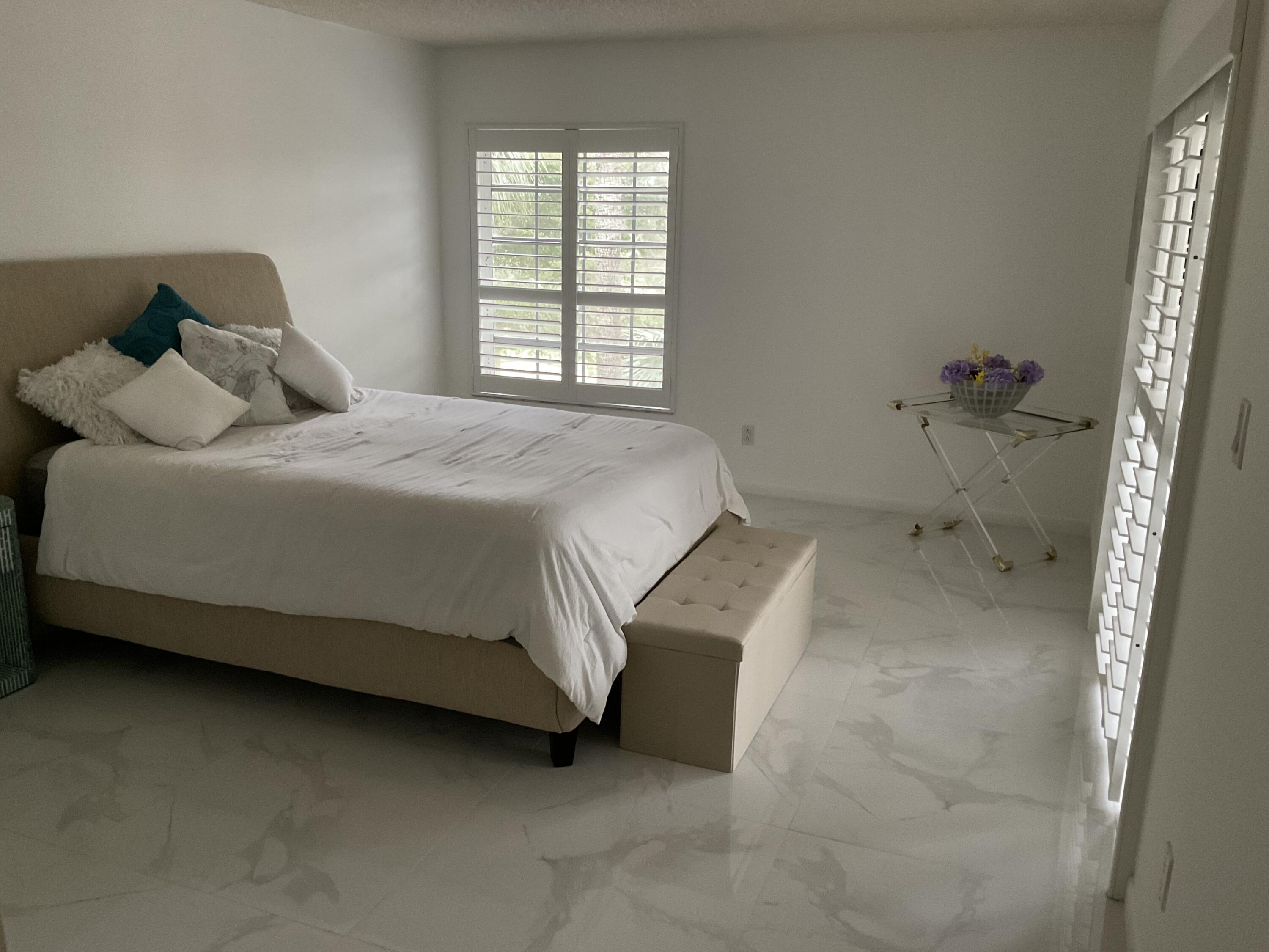 7370 Orangewood Lane, Unit 303 Boca Raton, FL 33433 - Photo 33 of 45 a bedroom with a bed and window