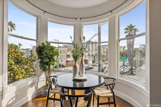 a view of a dining room with furniture a chandelier and wooden floor