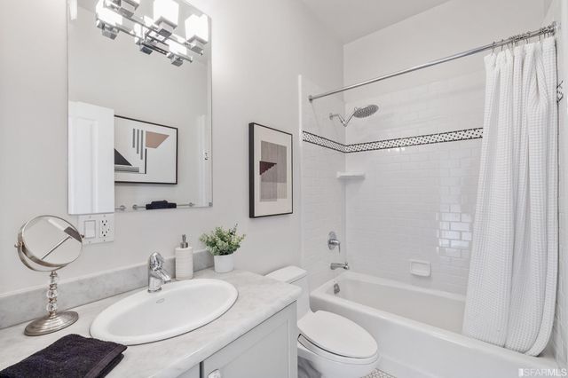 a bathroom with a granite countertop sink a toilet and shower