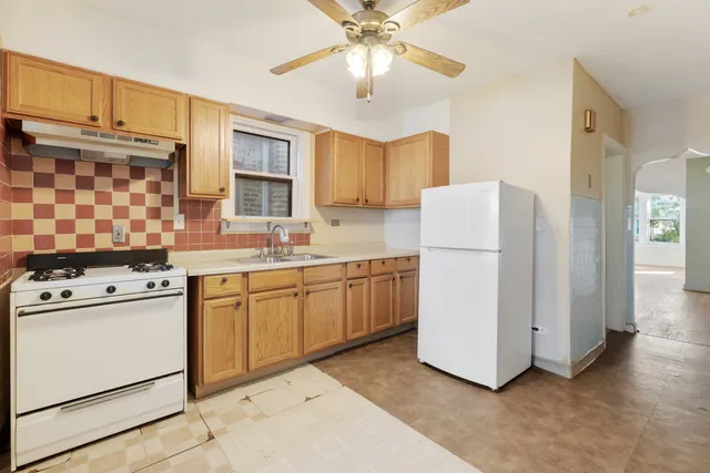 a kitchen with a refrigerator a stove a sink dishwasher and a refrigerator with wooden floor