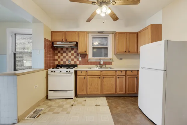 a kitchen with kitchen island white cabinets a refrigerator and a stove