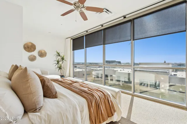 a living room with couches and kitchen view with wooden floor