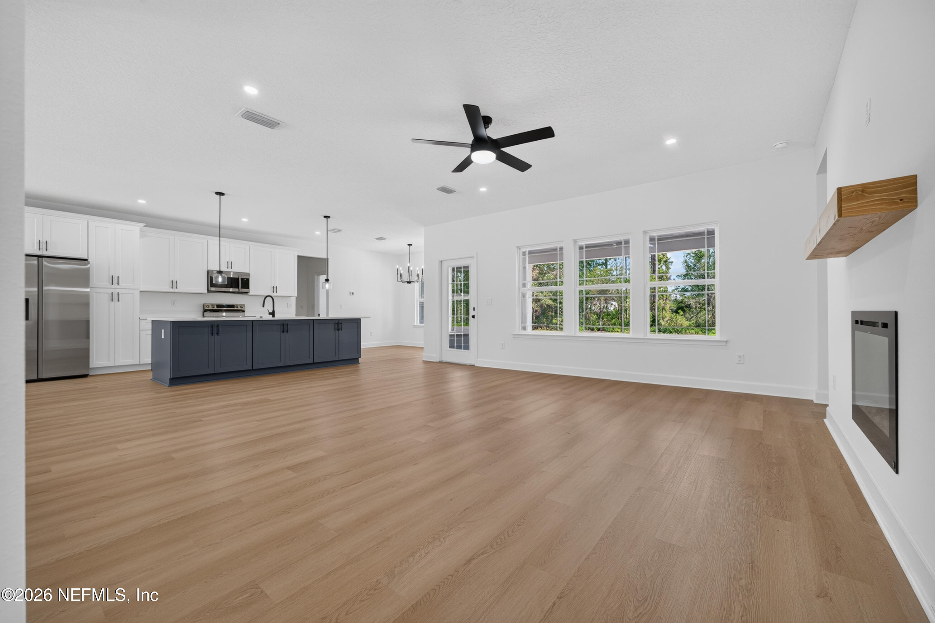 4362 Angora Street Middleburg, FL 32068 - Photo 21 of 31 a view of a kitchen with a stove cabinets wooden floor and a ceiling fan