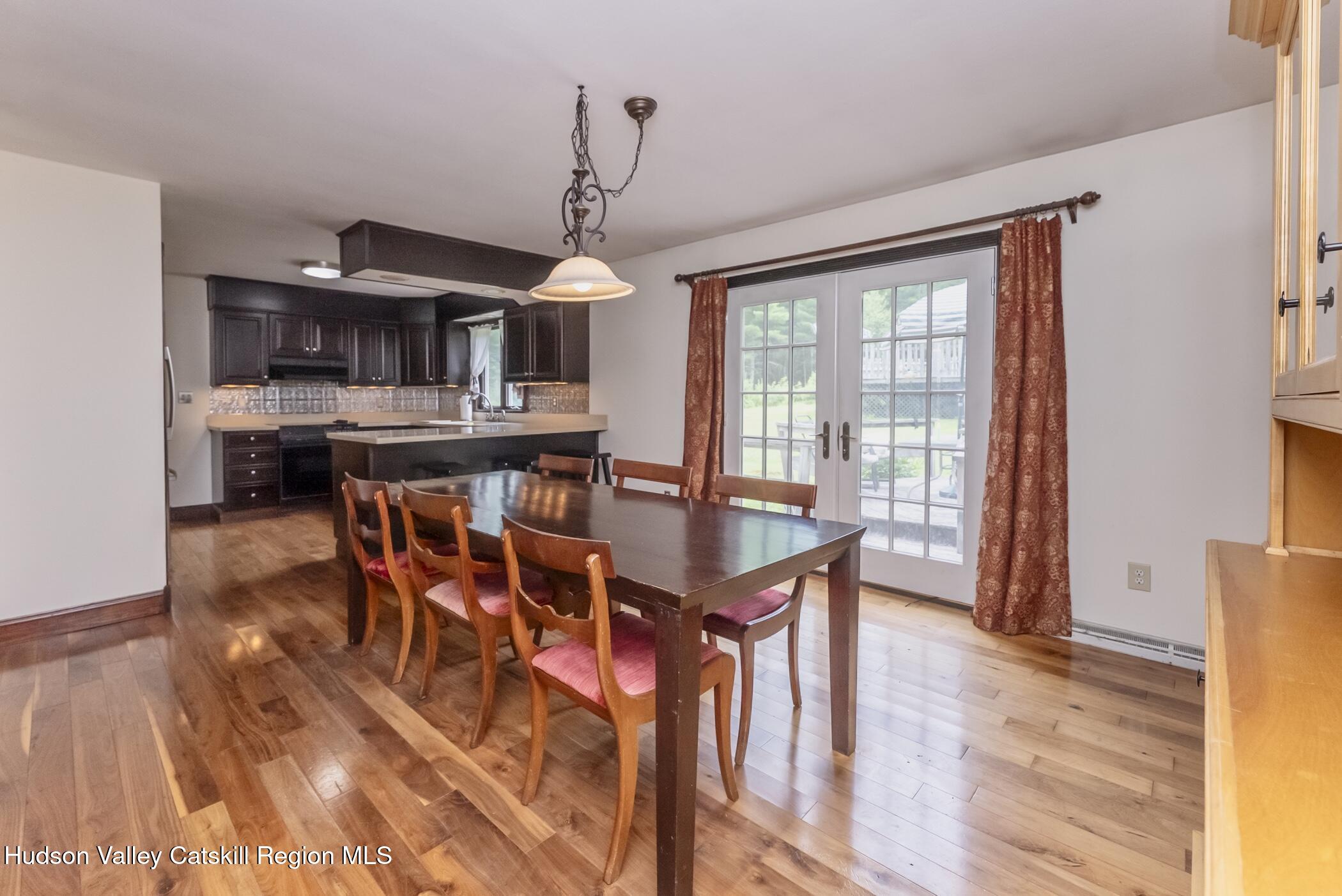 137 Bush Road Stone Ridge, NY 12484 - Photo 12 of 39 a dining room with furniture a chandelier and wooden floor