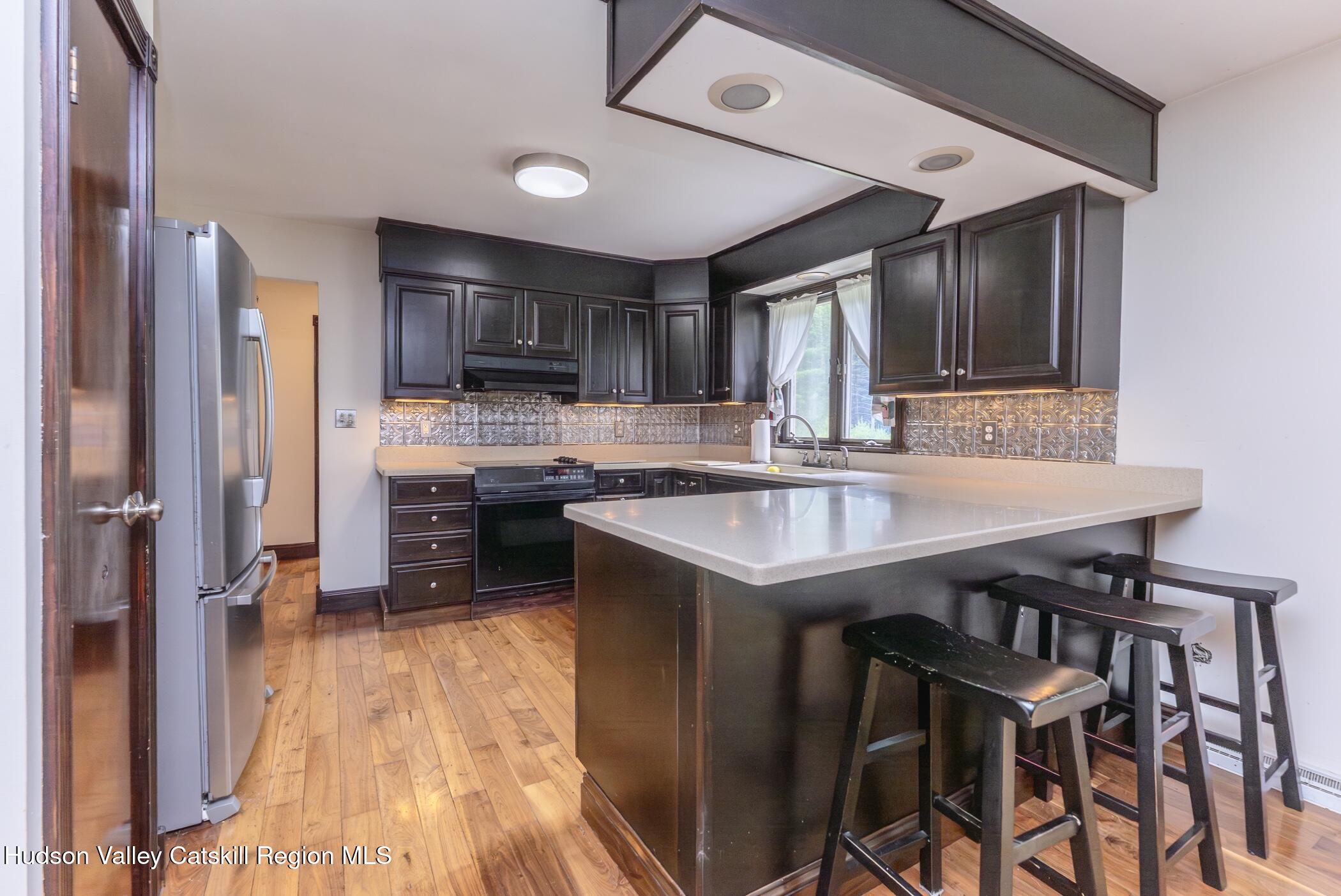 137 Bush Road Stone Ridge, NY 12484 - Photo 14 of 39 a kitchen with a table chairs refrigerator and cabinets
