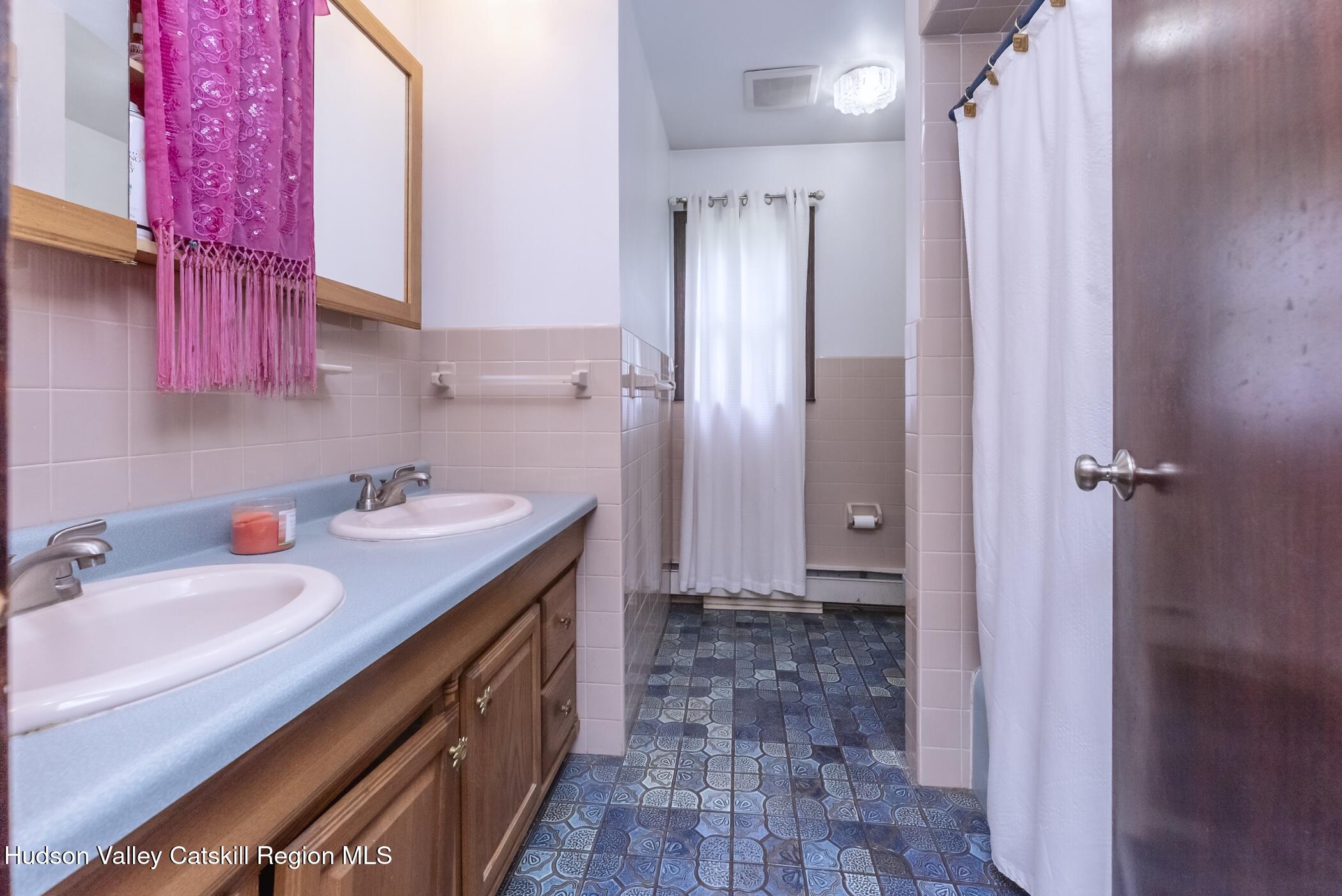 137 Bush Road Stone Ridge, NY 12484 - Photo 20 of 39 a bathroom with a double vanity sink a mirror and a shower