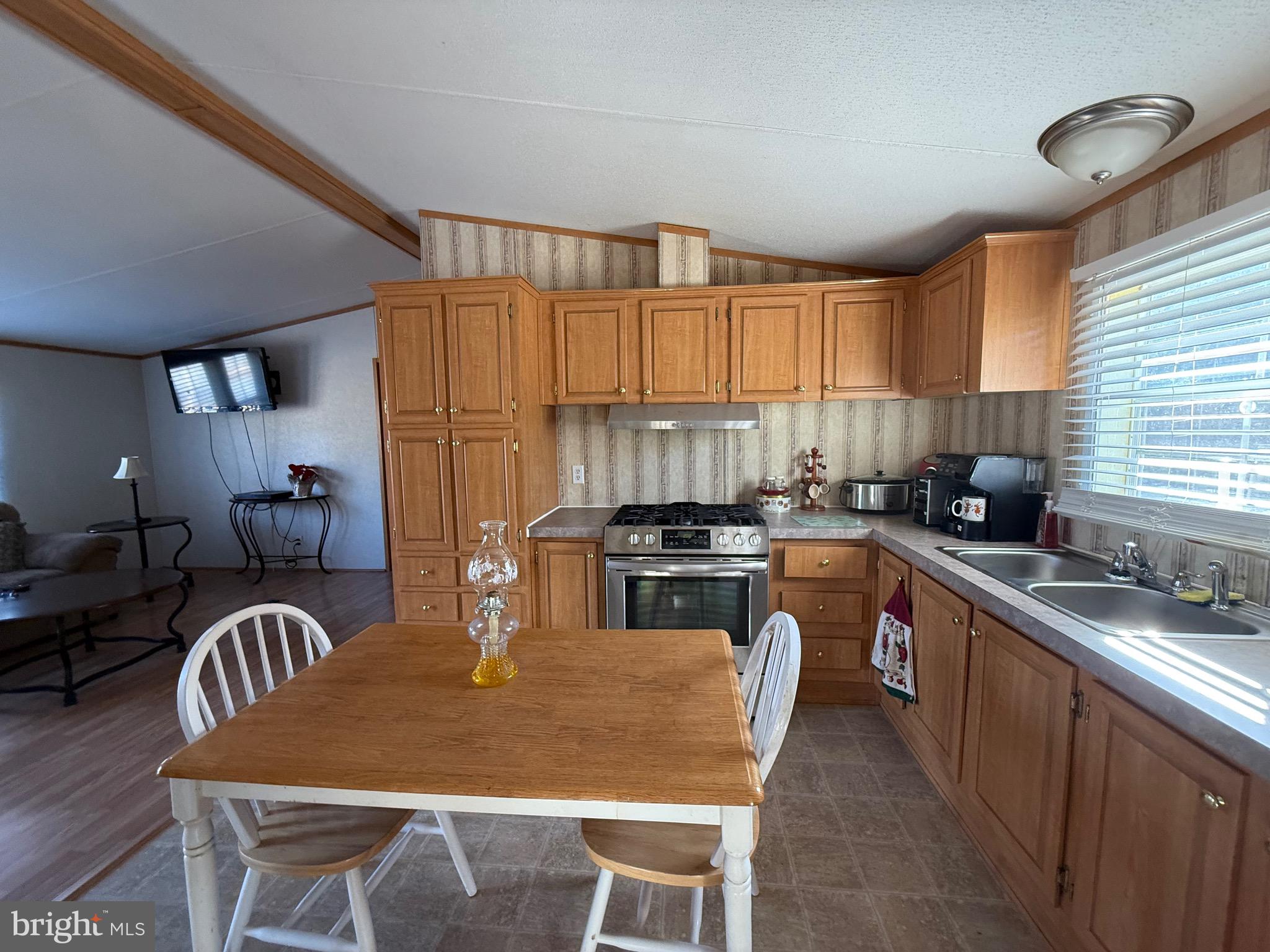 10323 Henry Road Berlin, MD 21811 - Photo 14 of 19 a kitchen with a stove a sink a dining table and chairs