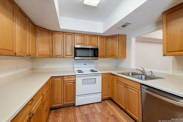 a kitchen with a sink stove and cabinets