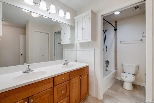a spacious bathroom with a double vanity sink mirror and toilet
