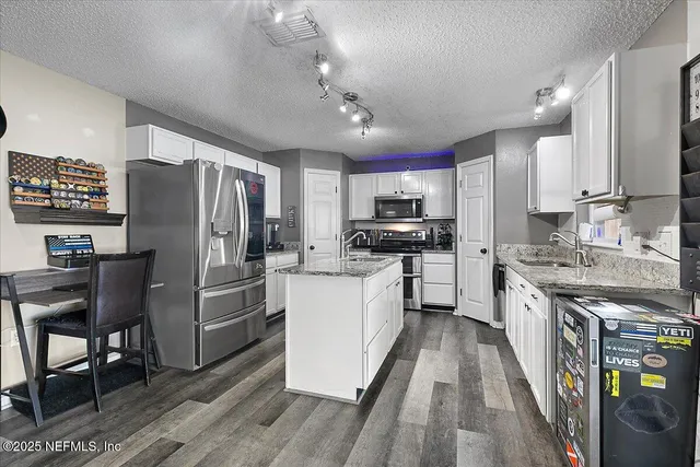 a kitchen with stainless steel appliances a refrigerator stove microwave and cabinets