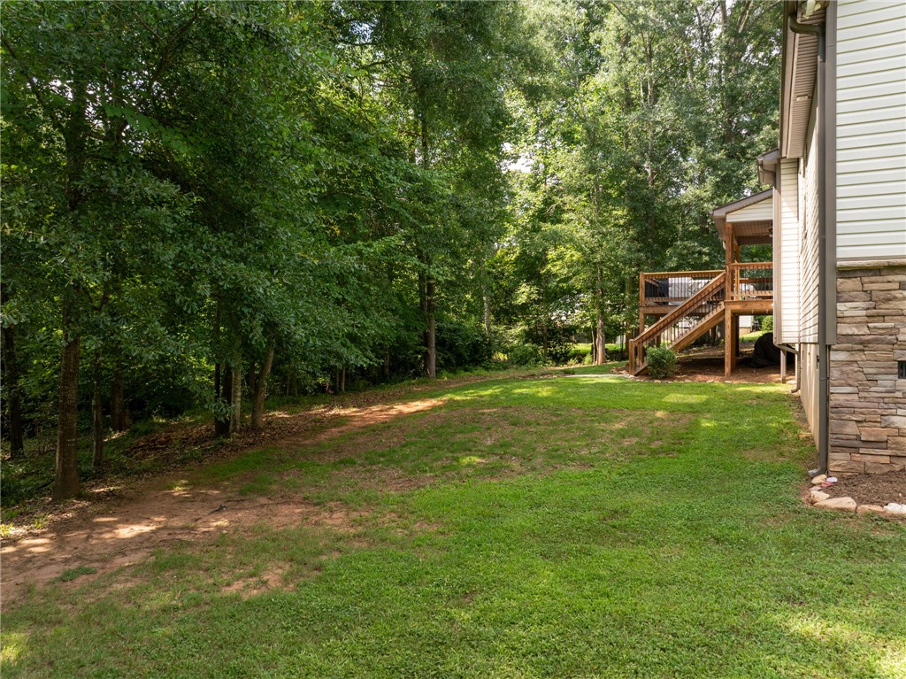 201 Hearthstone Drive Anderson, SC 29621 - Photo 44 of 49 Enjoy the verdant backyard with a wooden deck extending from the residence, perfect for outdoor living.