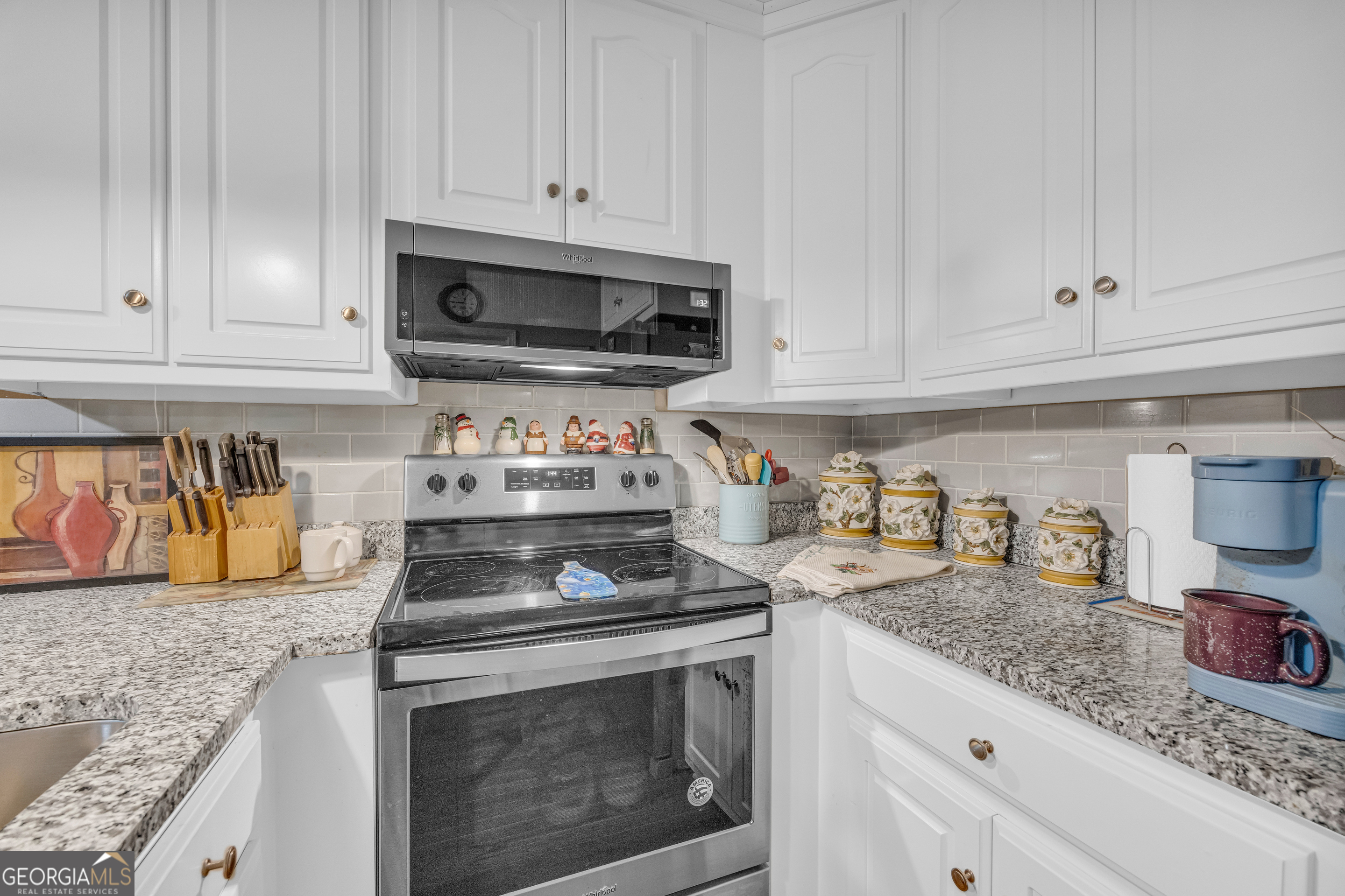 26 Chief Lane Hartwell, GA 30643 - Photo 24 of 65 a kitchen with granite countertop white cabinets and stainless steel appliances