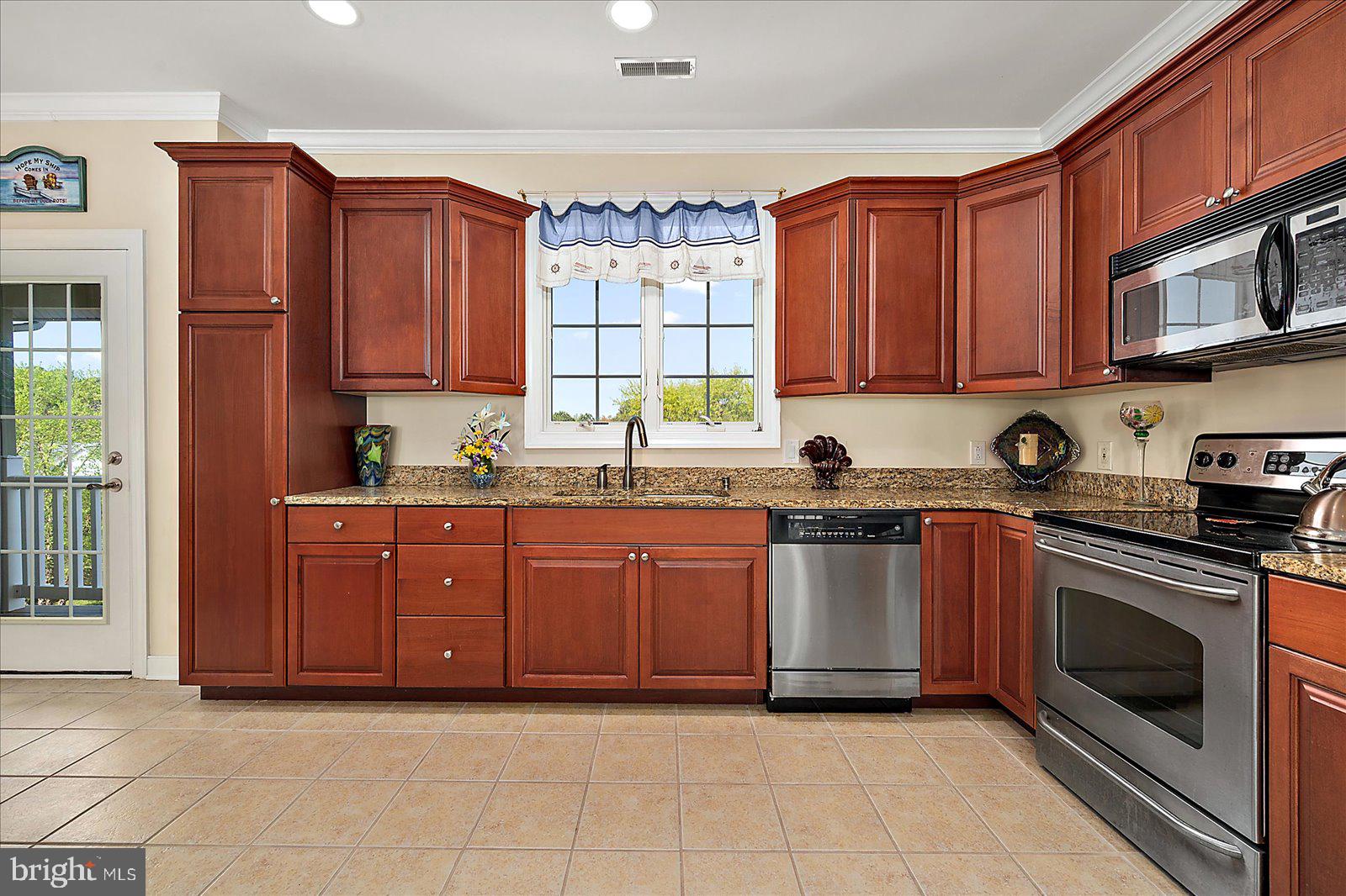 9823 Golf Course Road, Unit 7 Ocean City, MD 21842 - Photo 22 of 76 a kitchen with stainless steel appliances granite countertop a stove top oven a sink dishwasher and cabinets with wooden floor