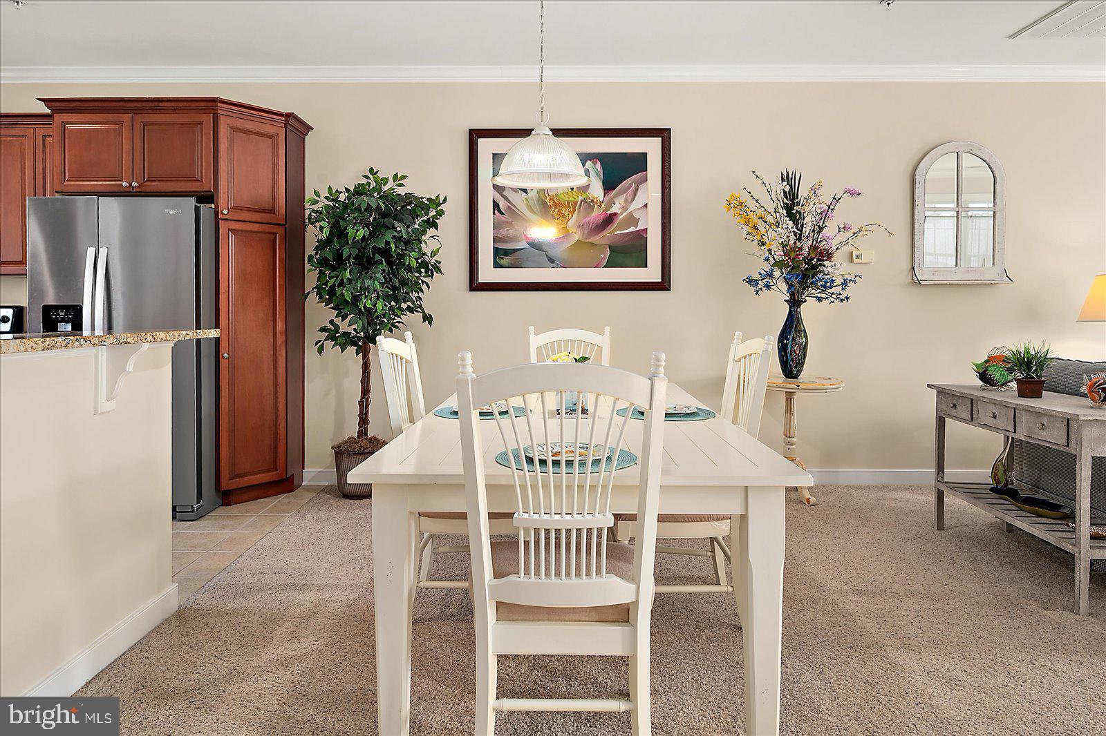 9823 Golf Course Road, Unit 7 Ocean City, MD 21842 - Photo 25 of 76 a view of a dining room with furniture a kitchen and a chandelier