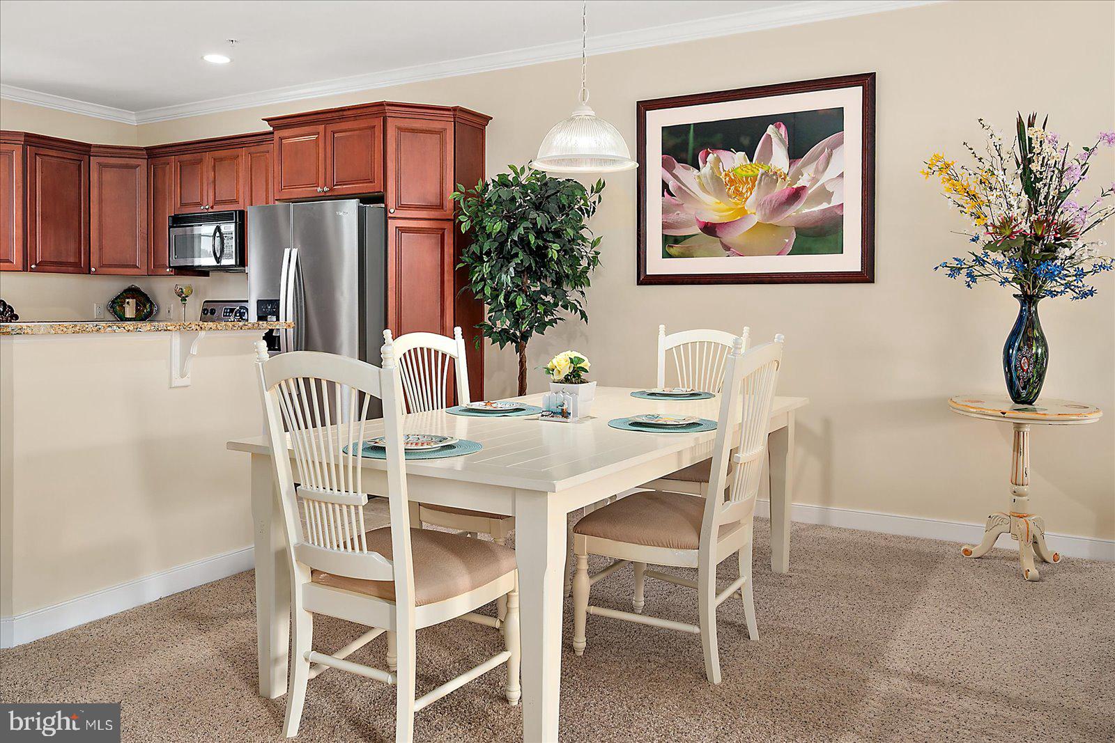 9823 Golf Course Road, Unit 7 Ocean City, MD 21842 - Photo 26 of 76 a view of a dining room with furniture a kitchen and a chandelier