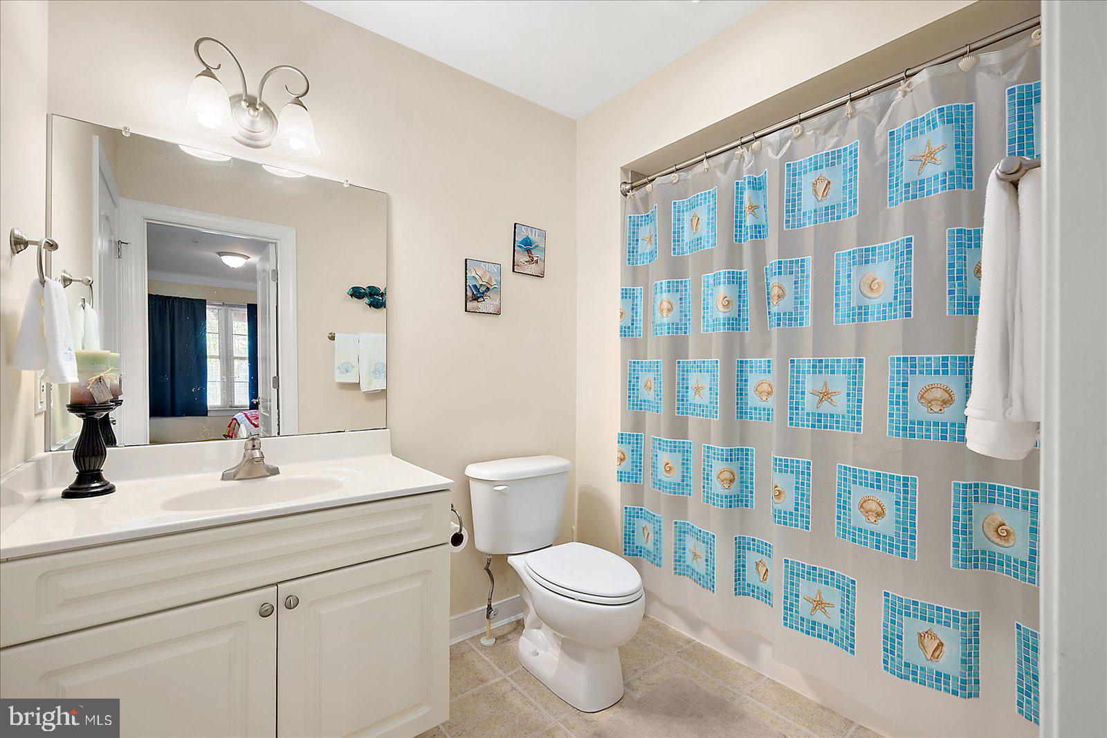 9823 Golf Course Road, Unit 7 Ocean City, MD 21842 - Photo 41 of 76 a bathroom with a sink a toilet and shower curtain