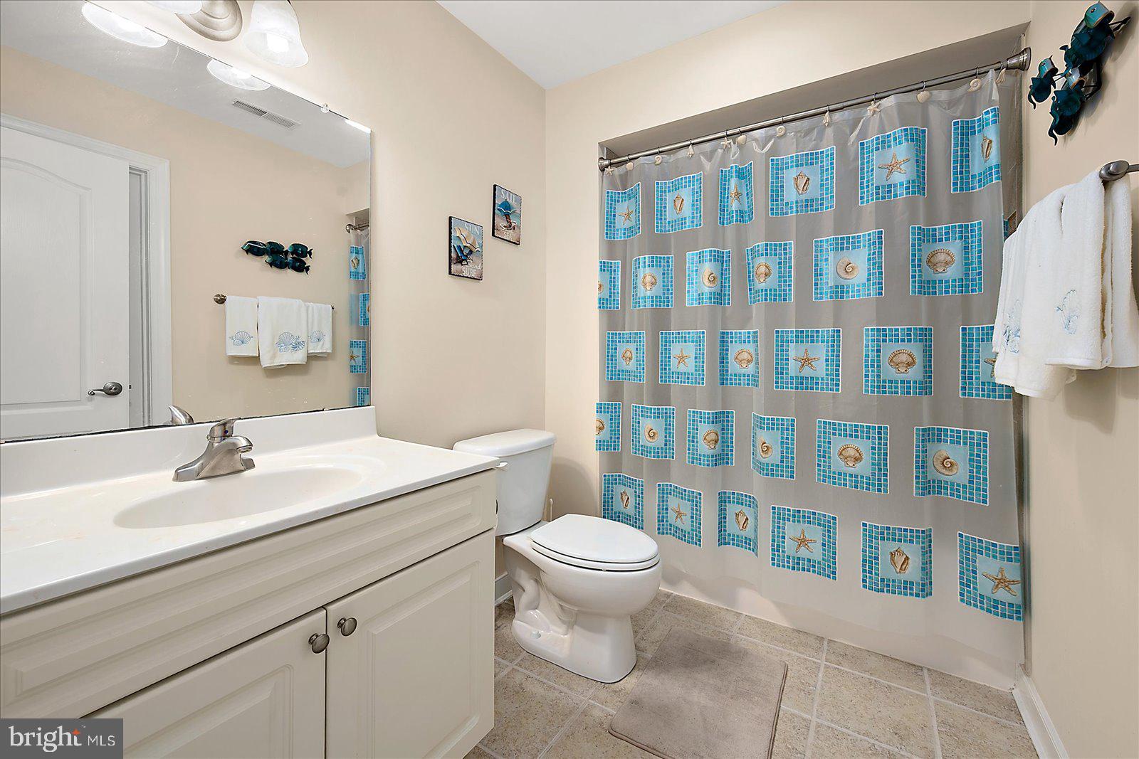 9823 Golf Course Road, Unit 7 Ocean City, MD 21842 - Photo 42 of 76 a bathroom with a sink a toilet and shower curtain