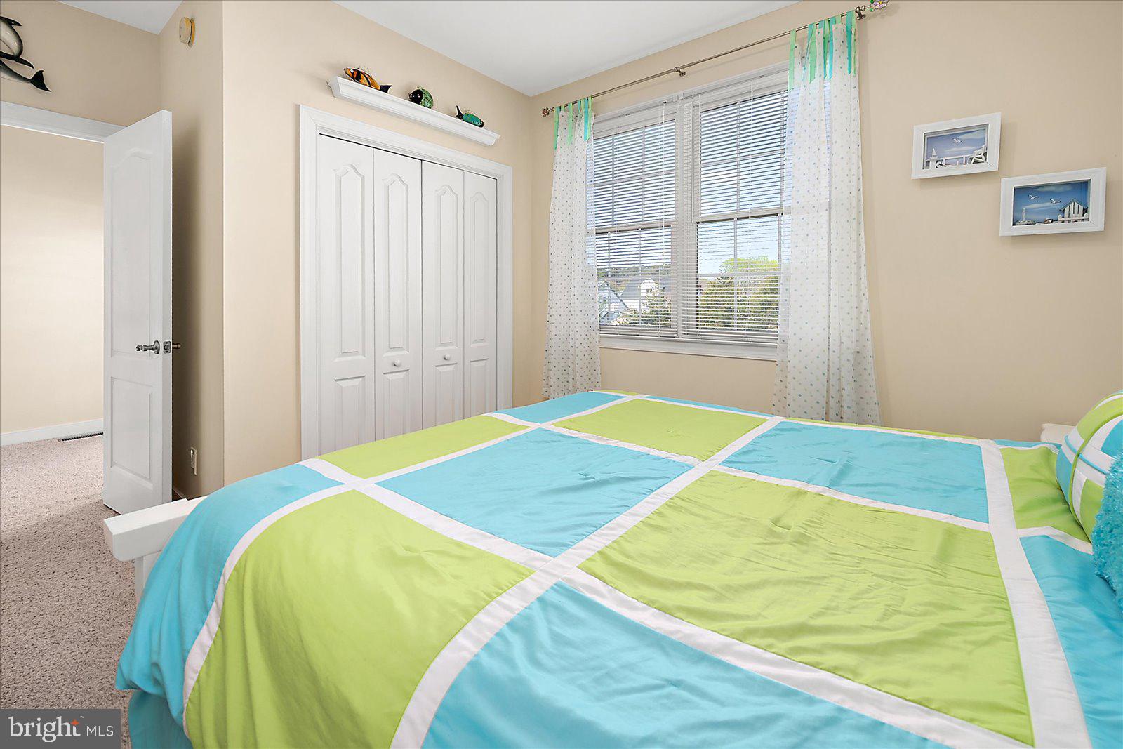 9823 Golf Course Road, Unit 7 Ocean City, MD 21842 - Photo 44 of 76 a bed sitting in a bedroom next to a window