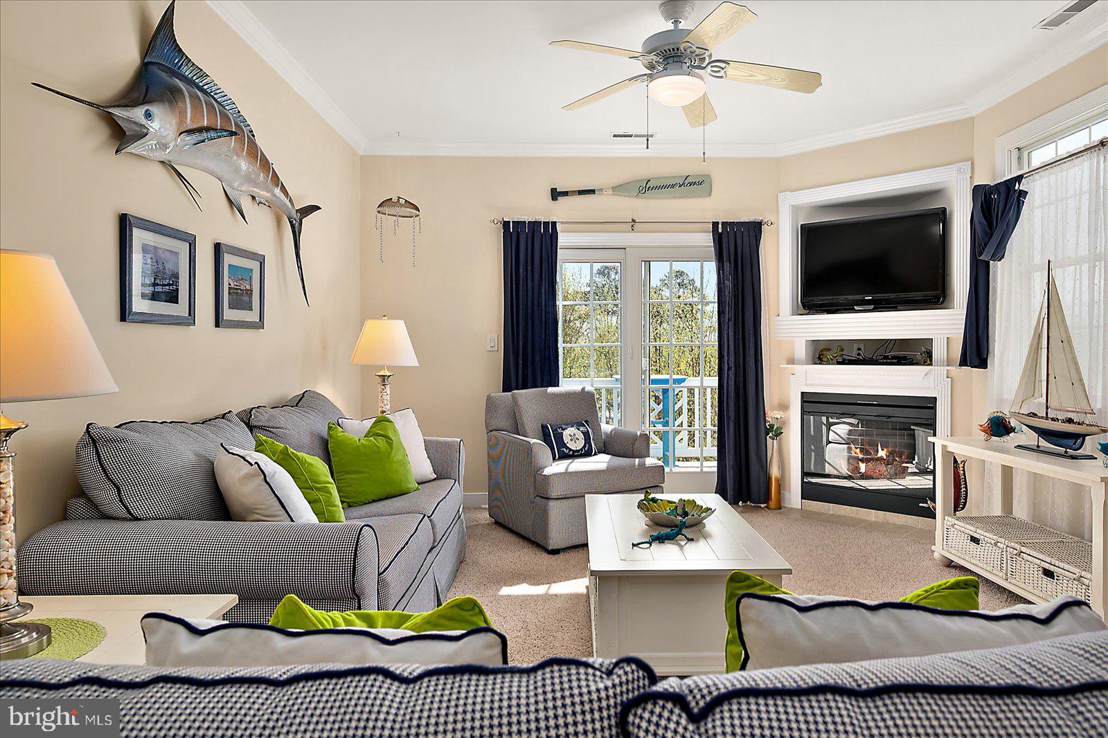 9823 Golf Course Road, Unit 7 Ocean City, MD 21842 - Photo 8 of 76 a living room with furniture a flat screen tv and a fireplace