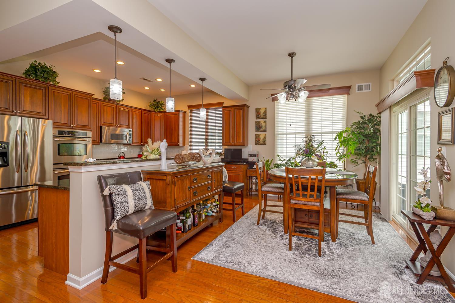 44 Kings Mill Road Monroe Township, NJ 08831 - Photo 13 of 38 a kitchen with stainless steel appliances granite countertop a table chairs and a refrigerator