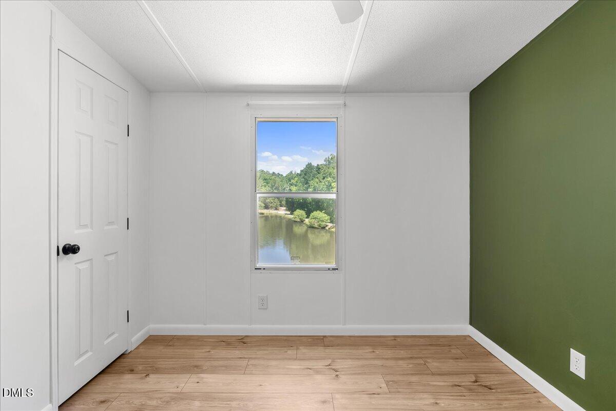 1111 Stoney Mountain Road Rougemont, NC 27572 - Photo 15 of 30 an empty room with wooden floor and windows