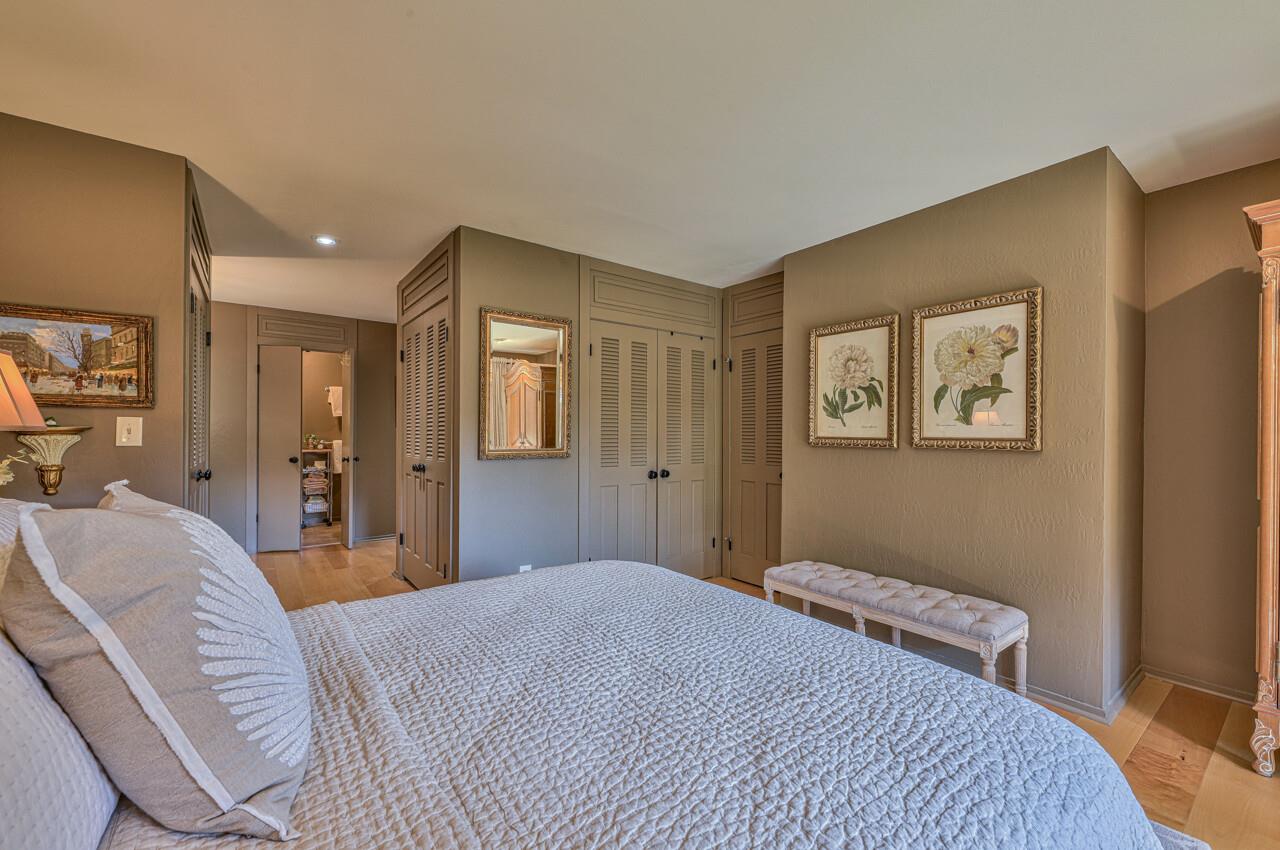 105 Del Mesa Carmel Carmel, CA 93923 - Photo 24 of 35 a bedroom with a large bed and a chandelier