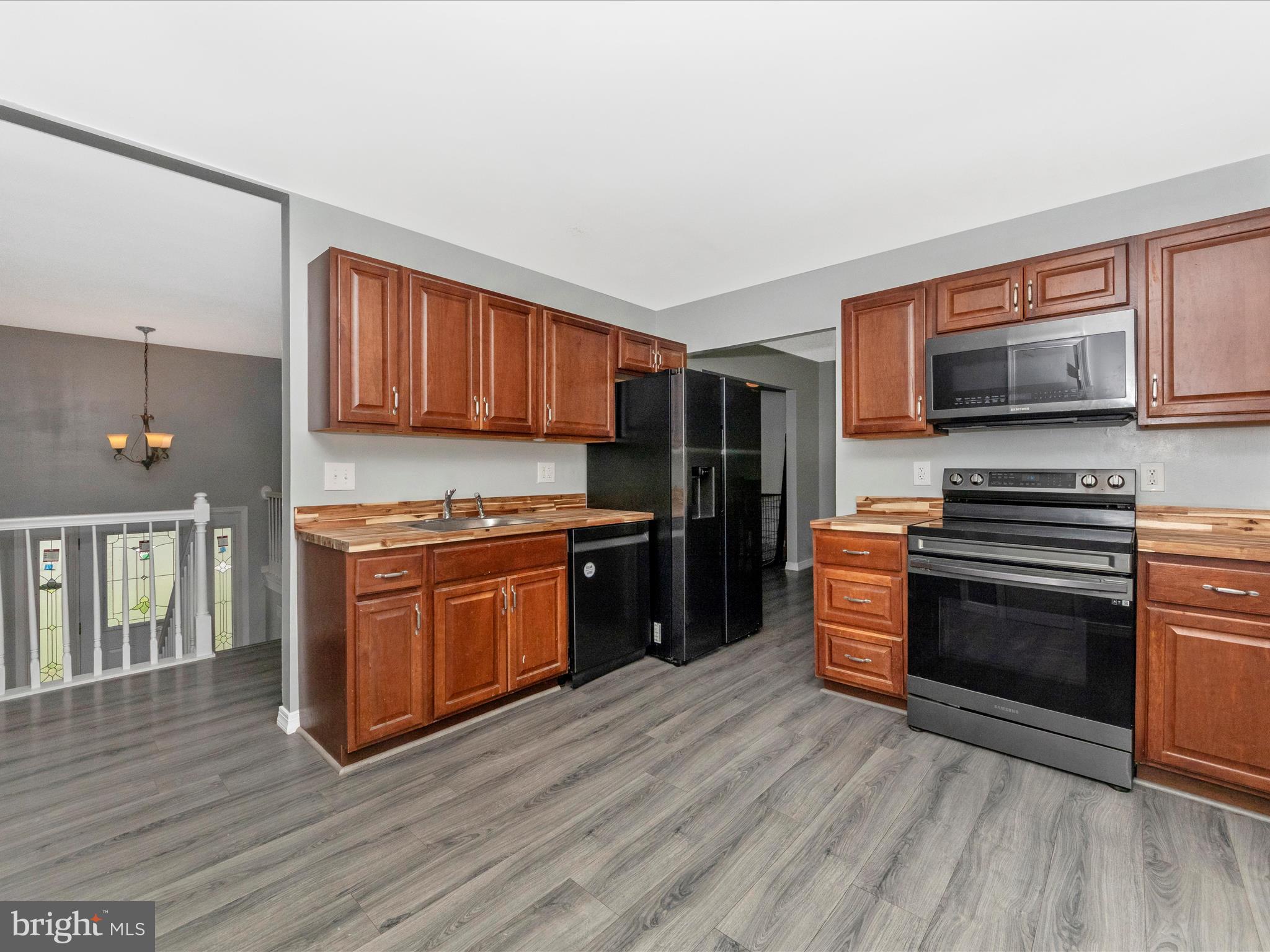 6503 Walker Branch Drive Laurel, MD 20707 - Photo 12 of 36 a kitchen with stainless steel appliances kitchen island granite countertop a stove a sink and a microwave