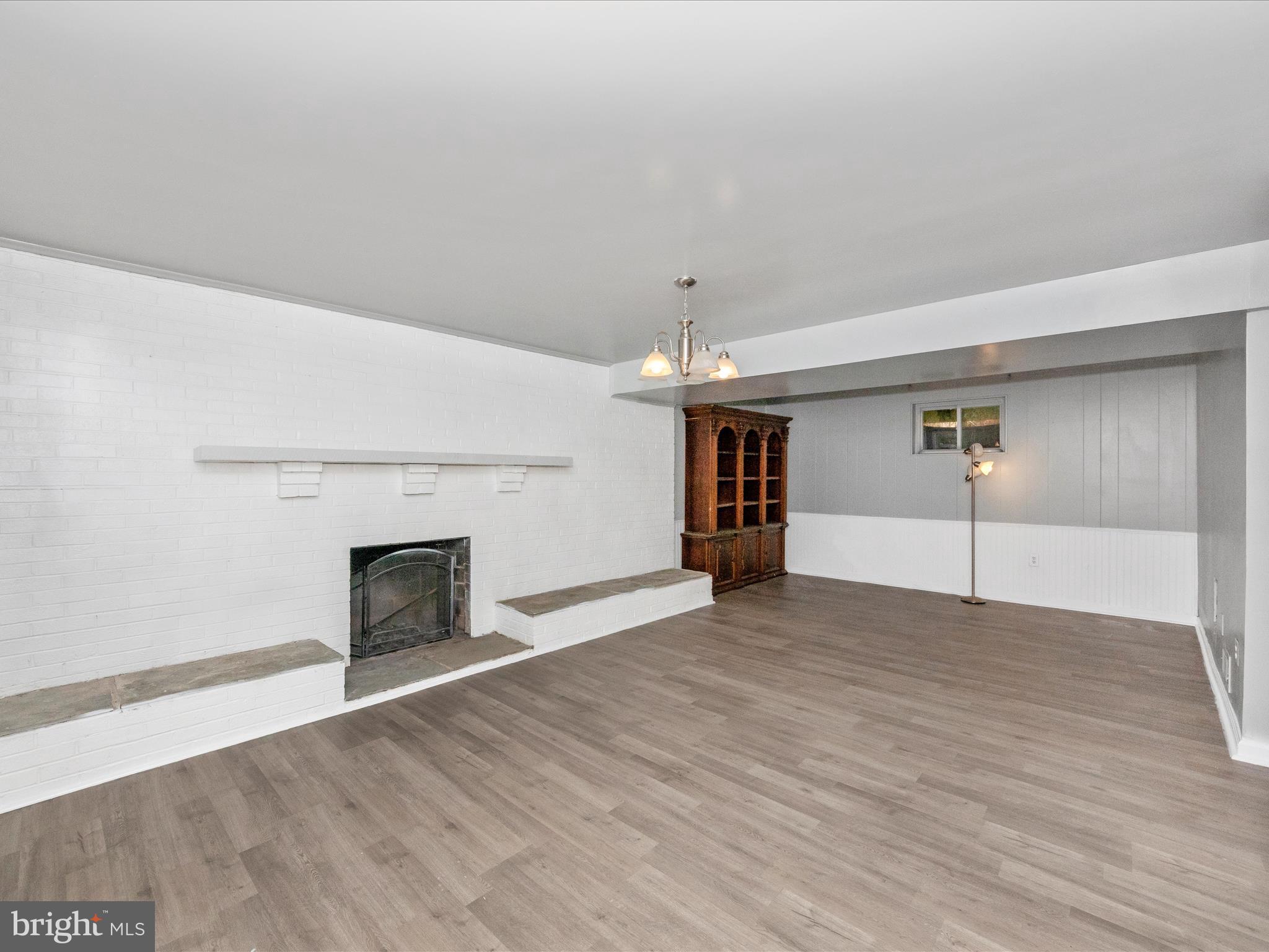6503 Walker Branch Drive Laurel, MD 20707 - Photo 23 of 36 an empty room with wooden floor fireplace and windows