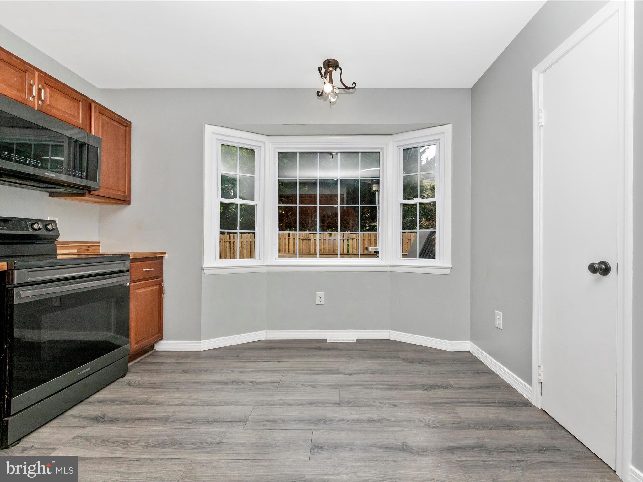 6503 Walker Branch Drive Laurel, MD 20707 - Photo 10 of 36 a view of an empty room with wooden floor and a kitchen