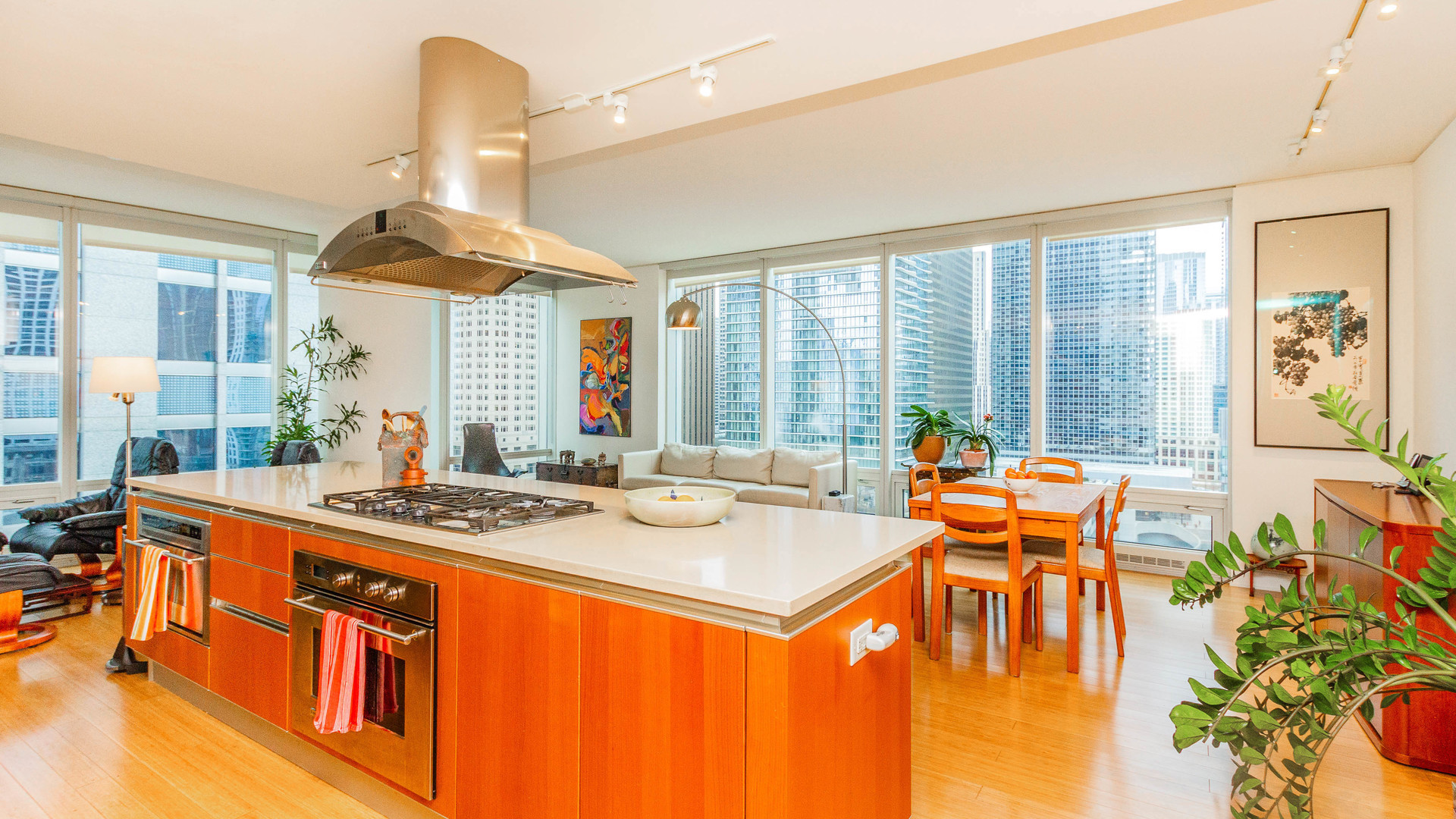 340 East Randolph Street, Unit 1106 Chicago, IL 60601 - Photo 6 of 19 a dining hall with stainless steel appliances granite countertop a sink a stove and a dining table with wooden floor
