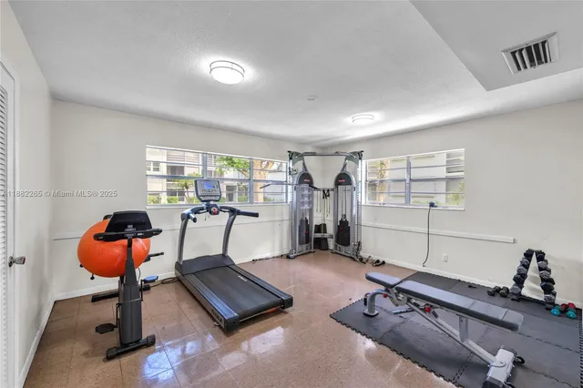 a room with gym equipment and a chandelier