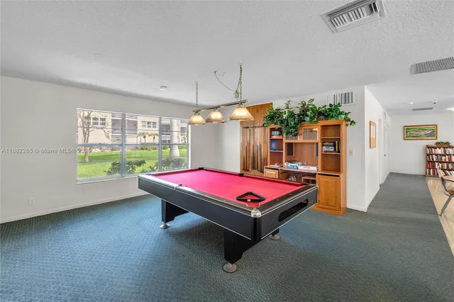 a room with pool table and windows