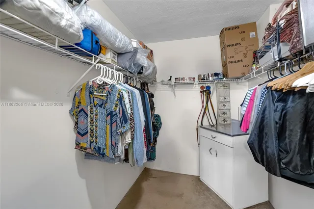 a view of walk in closet with clothes and shoes
