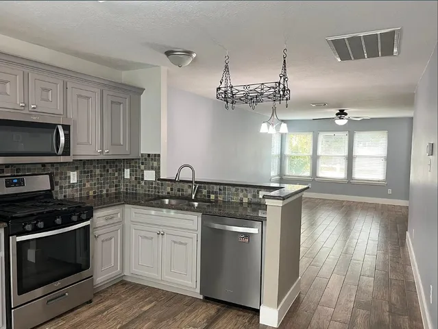 a kitchen with stainless steel appliances granite countertop a stove and a sink