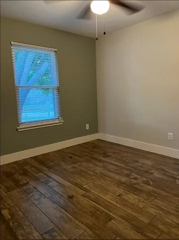 a view of a room with wooden floor and a window