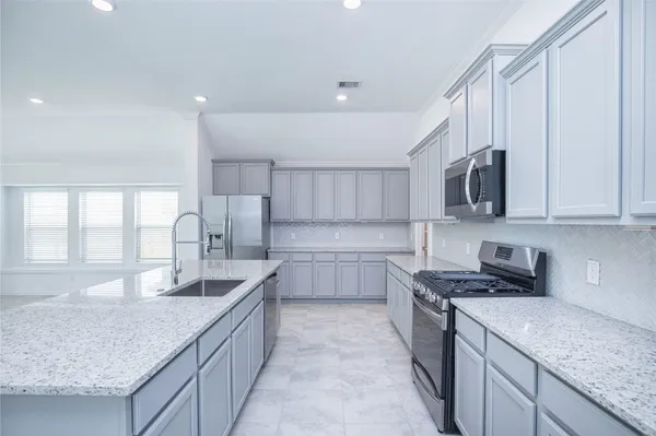 a kitchen with stainless steel appliances granite countertop a sink stove and cabinets