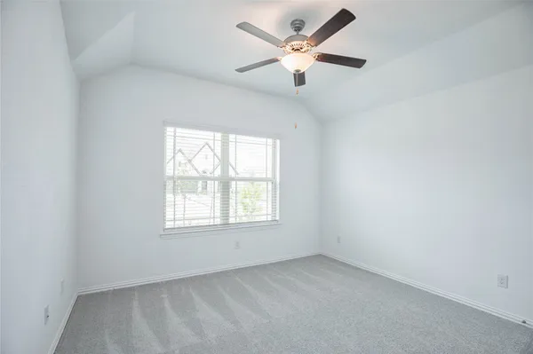 an empty room with closet and a chandelier fan