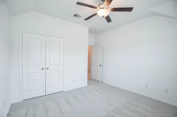 an empty room with a ceiling fan and a fan