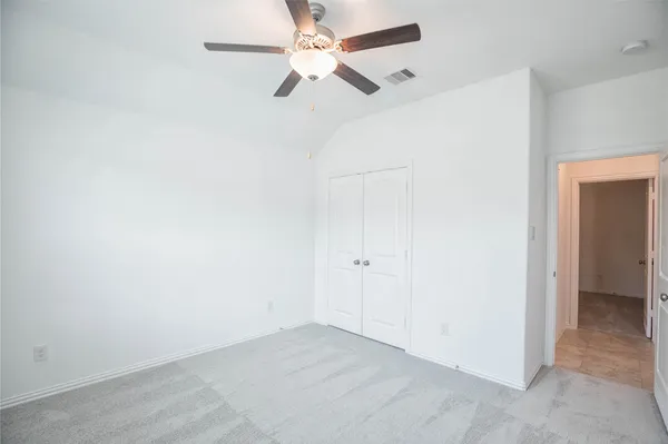 an empty room with a window and a fan
