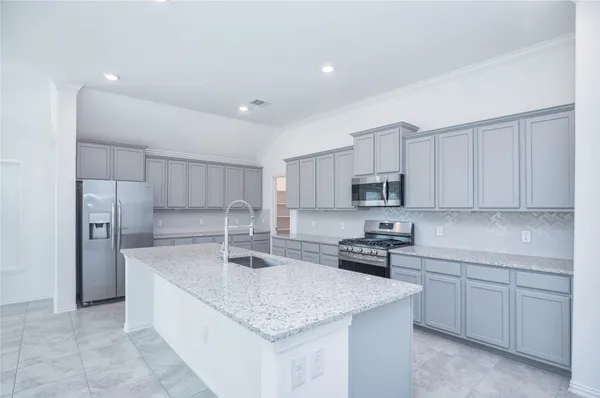 a large kitchen with kitchen island granite countertop a large counter top and a sink