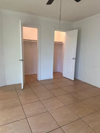 a view of empty room with window and chandelier fan